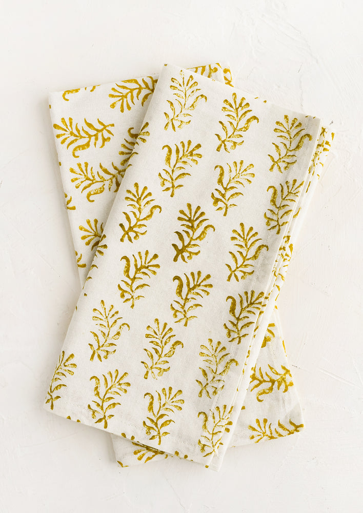A pair of block printed napkins in white with yellow floral print.