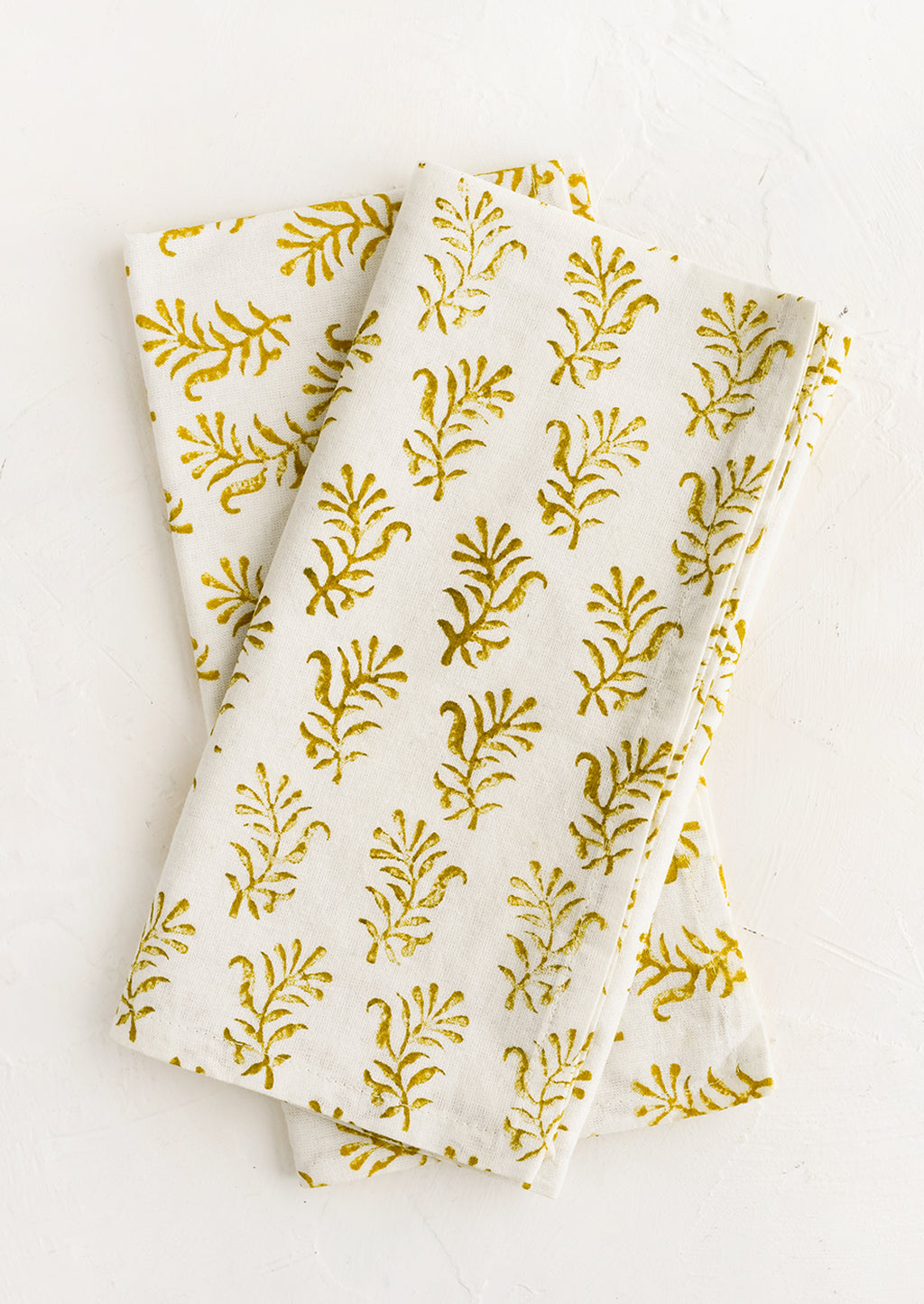 1: A pair of block printed napkins in white with yellow floral print.