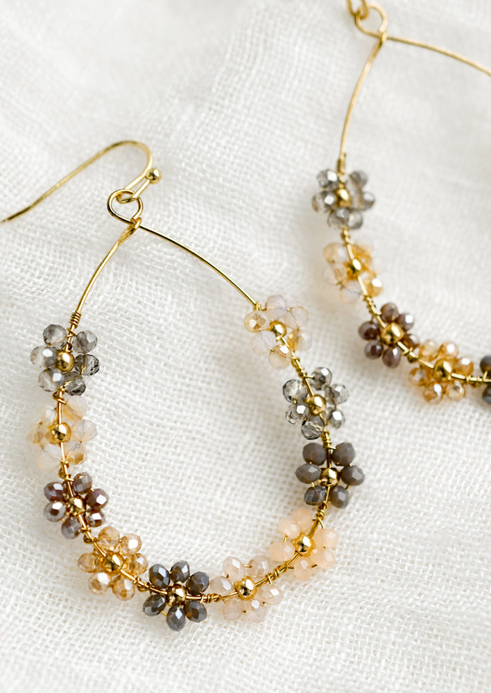 Neutral Multi: A pair of gold teardrop wire earrings with pastel floral beading.