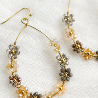 Neutral Multi: A pair of gold teardrop wire earrings with pastel floral beading.