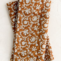 Amber Multi: A pair of amber and white colored napkins with floral print.