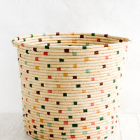 2: A round raffia hamper in natural with colorful dashes throughout.