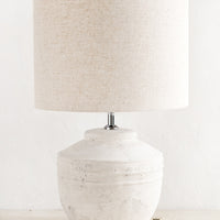 1: A white distressed concrete table lamp with a natural linen shade.