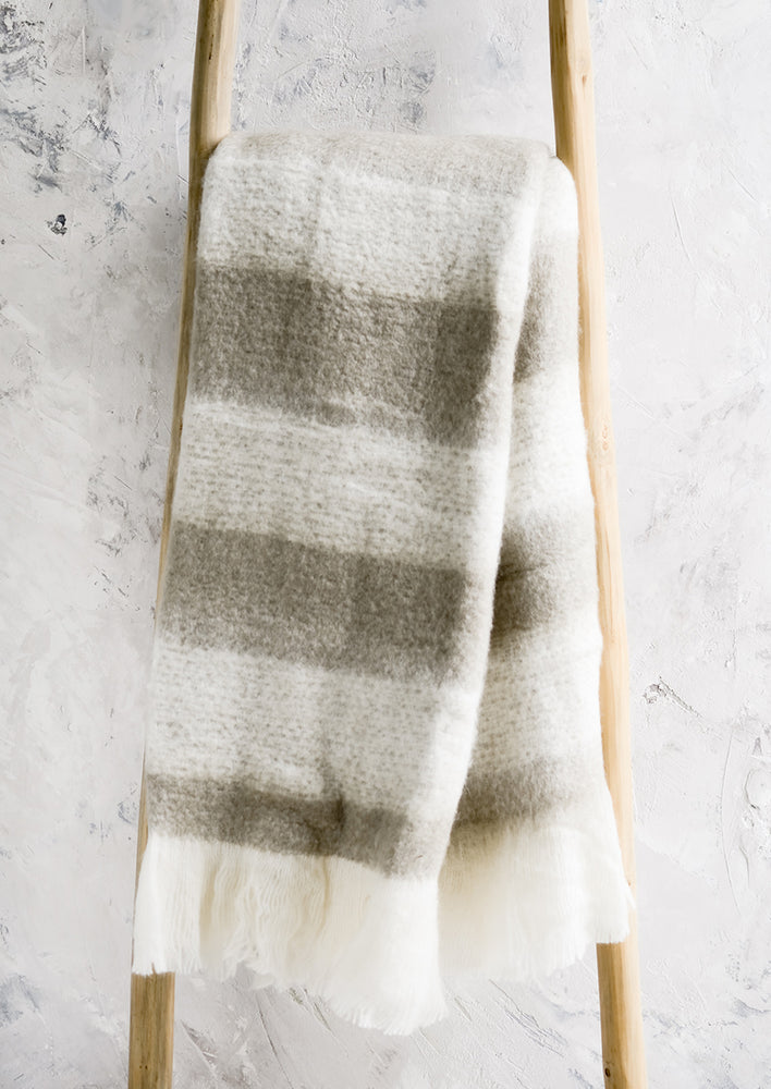 A fuzzy throw blanket in tan and white stripes.