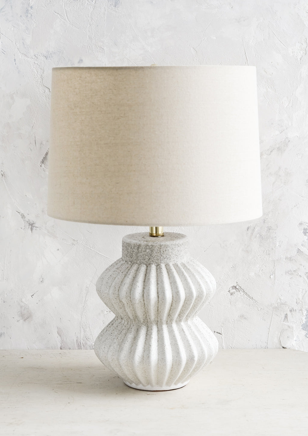 1: A table lamp with fluted ceramic base in speckled gray and natural linen shade.