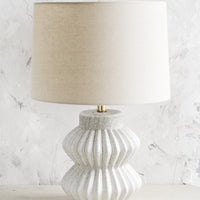 1: A table lamp with fluted ceramic base in speckled gray and natural linen shade.