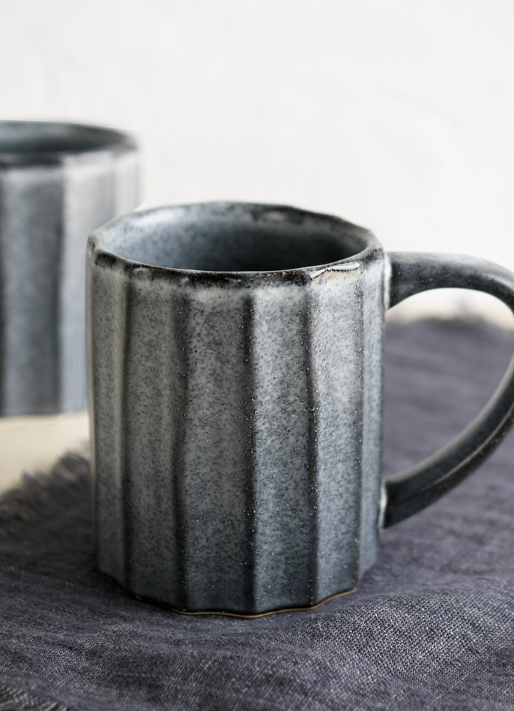 A fluted ceramic mug in denim blue.