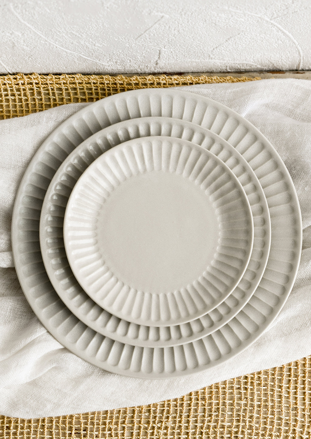 2: White fluted plates in three incremental sizes.