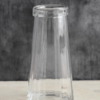 1: A tall, clear glass vase with slight fluted texture and rolled rim.