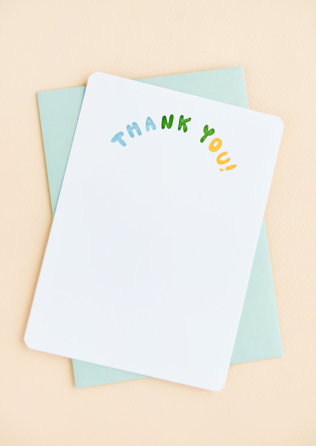 2: A white notecard with "Thank you" in colorblocked, arc-shaped text at top, paired with a turquoise envelope.