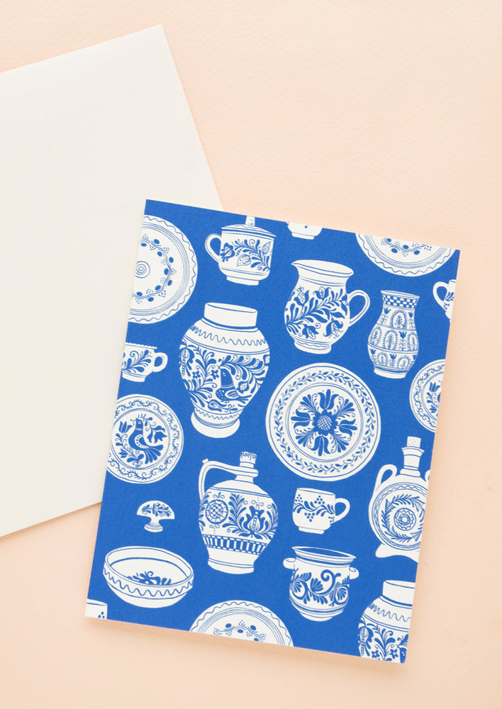 Folded greeting card in royal blue with blue & white pottery printed allover, paired with white envelope