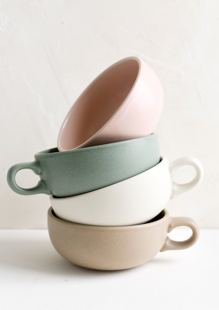2: A stacked tower of pastel colored mugs with handles.
