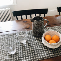 4: Dining table with table runner, water glasses, pitcher and bowl of oranges
