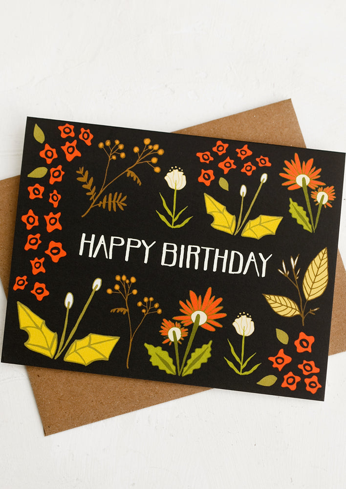 A black background floral print card reading "Happy Birthday".