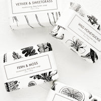 1: Four bars of soap in black & white botanical graphic packaging.