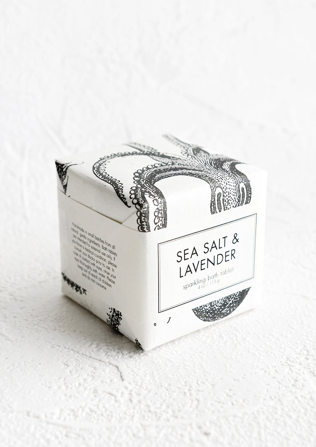 Sea Salt & Lavender: A cube-shaped bath fizzy box with black and white octopus graphic packaging.