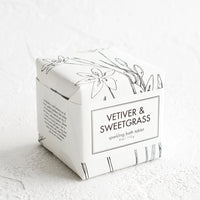 Vetiver & Sweetgrass: A cube-shaped bath fizzy box with black and white botanical graphic packaging.
