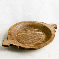 1: A round antique wooden tray with decorative side handles.