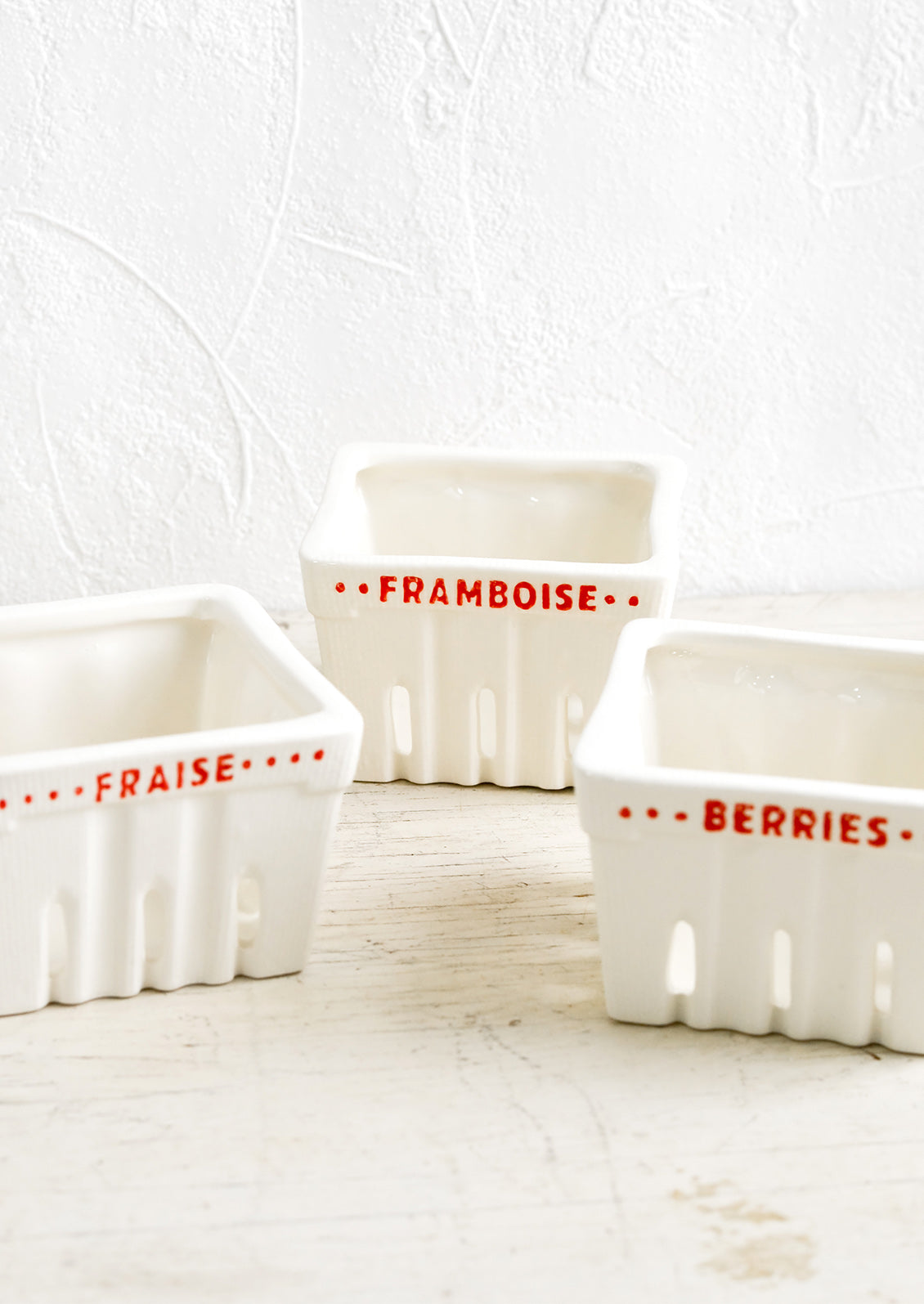 Ceramic berry baskets made to look like the disposable variety, but in white ceramic with red letters in French.