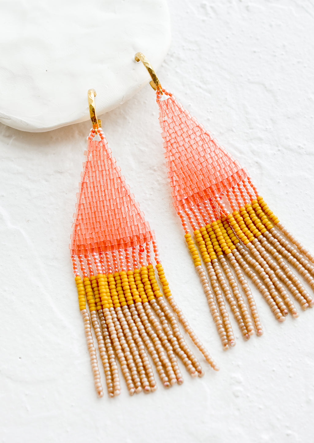 Cosmo Multi: Beaded earrings featuring pink, yellow and brown beads layered into fringe, dangling from a gold hoop.