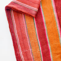 1: Woven textile intended for use as a rug or blanket, variegated colorful striped pattern.