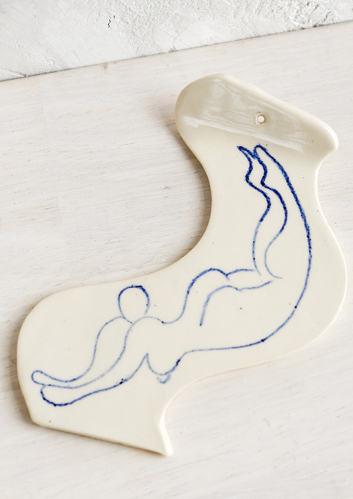 1: A ceramic incense holder with line drawn naked woman diving.