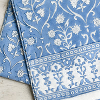 1: A floral print tablecloth in blue and white.