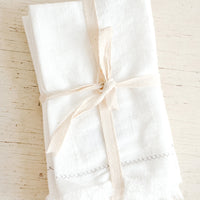 1: White cotton dinner napkins folded and bound with twine