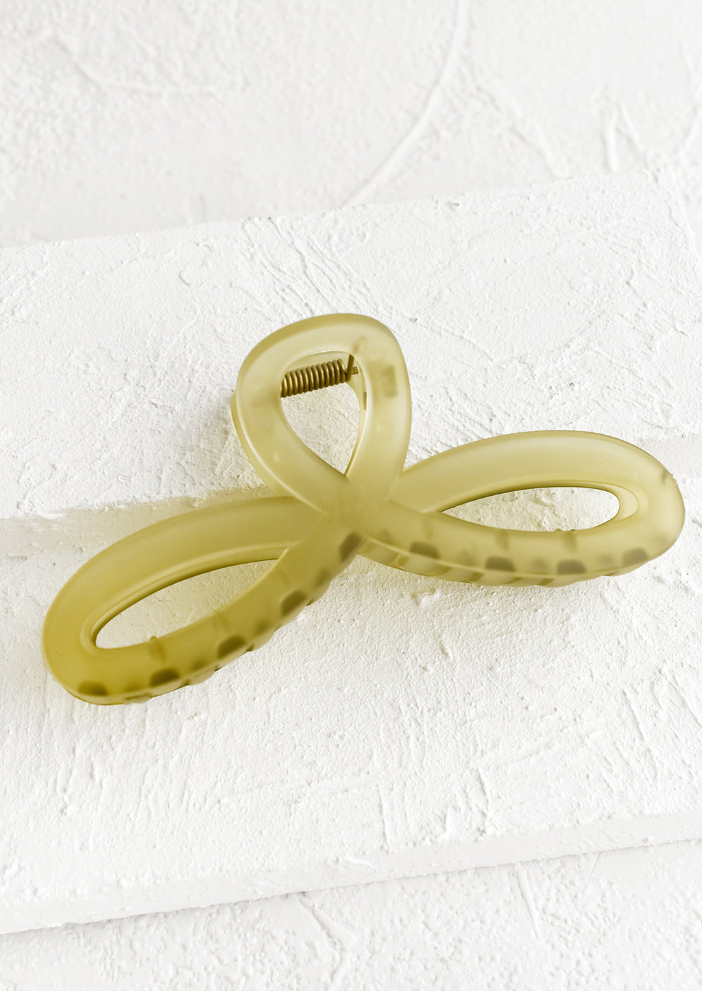 Matte Olive: A curvy hair clip with knotted loop design in frosted olive.
