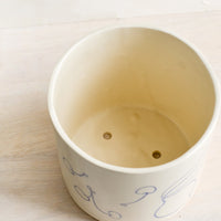 3: A ceramic planter with drainage holes at bottom.