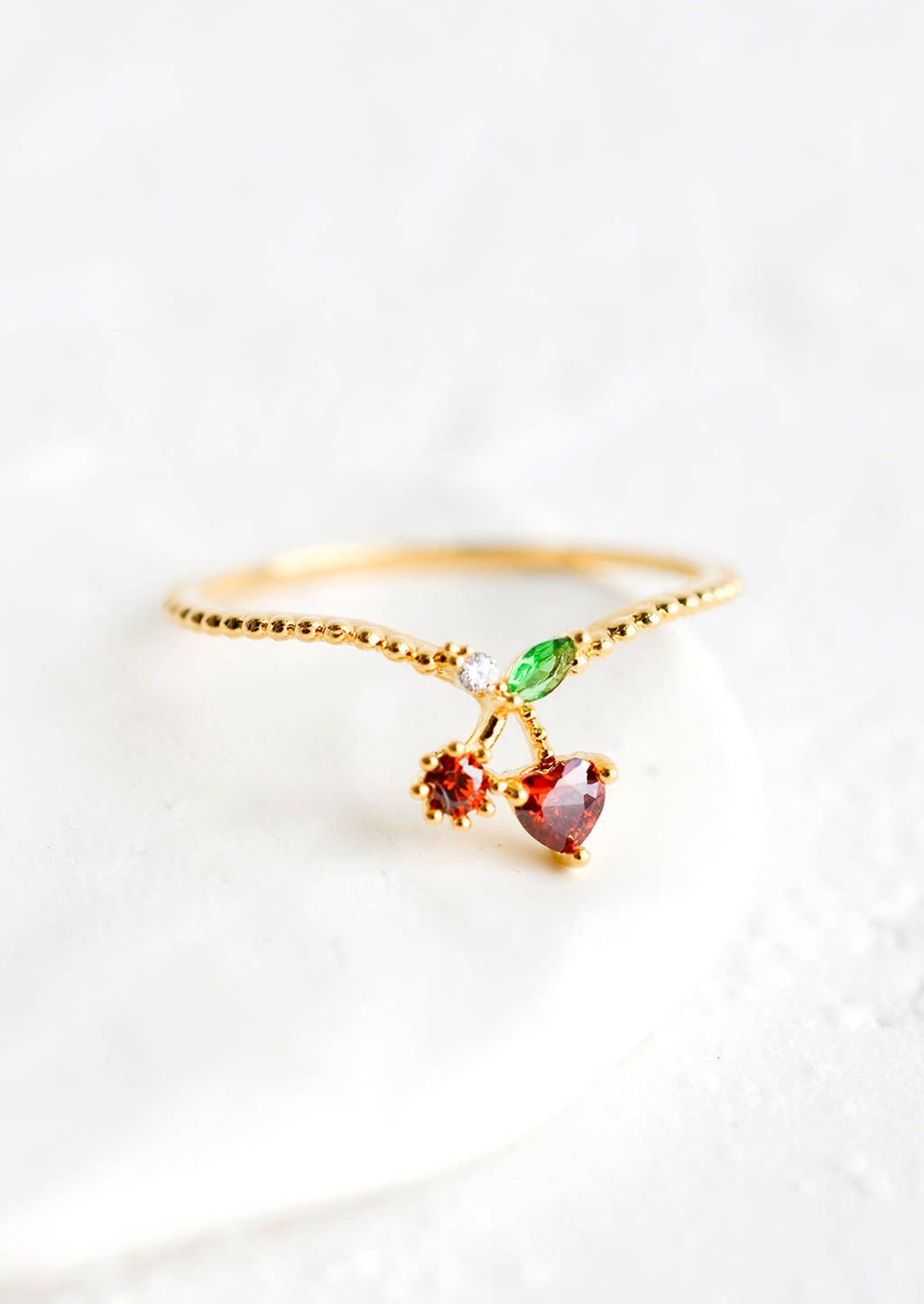 Cherry / Size 5: A gold ring with beaded texture and cherry shaped crystal front.