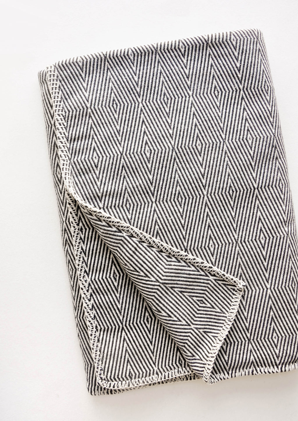 1: Cotton blanket with allover geometric diamond pattern in black and white