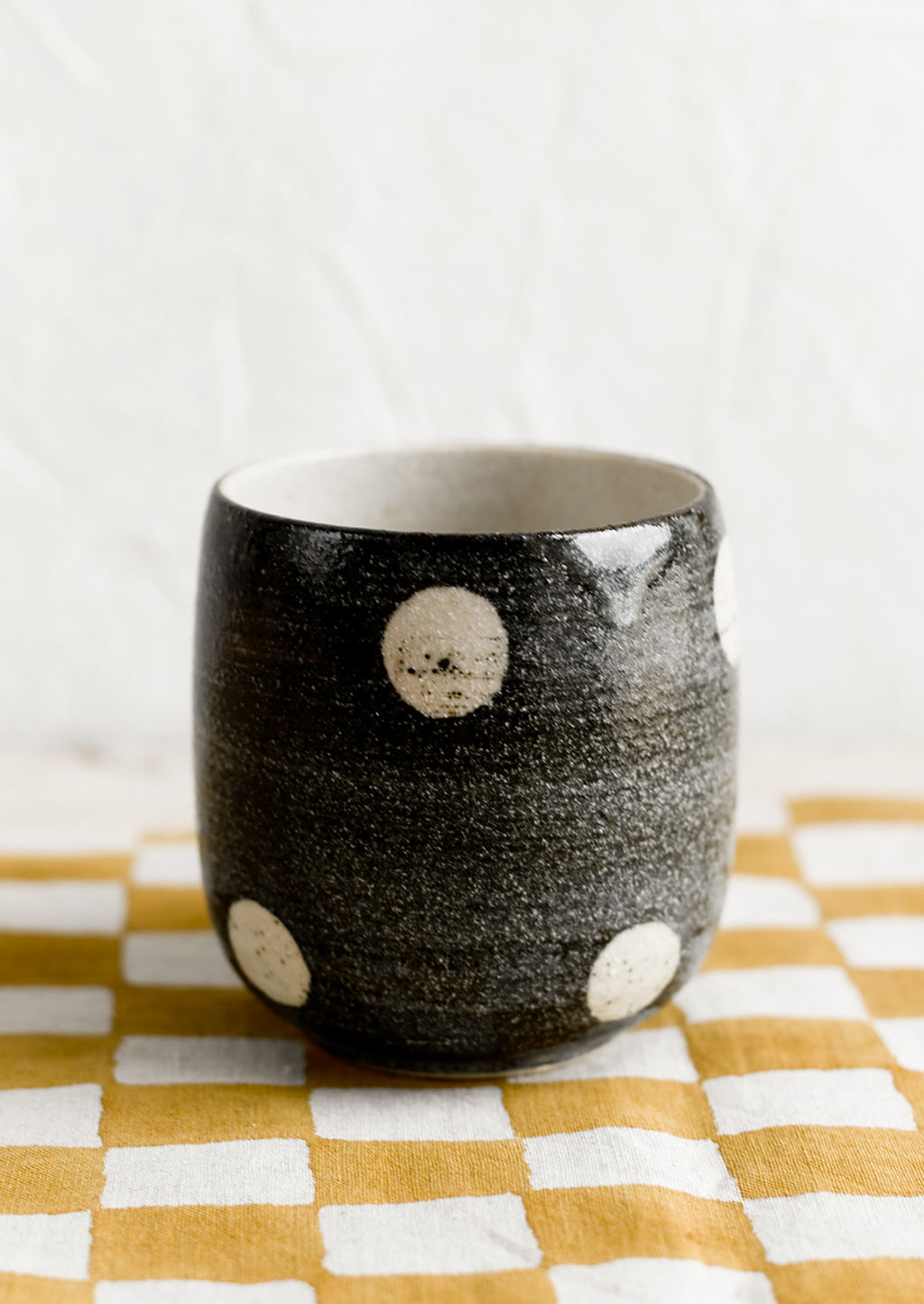 Black: A black ceramic cup with white polka dots.