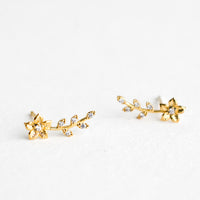2: A pair of gold climber stud earrings with floral design decorated with crystals.