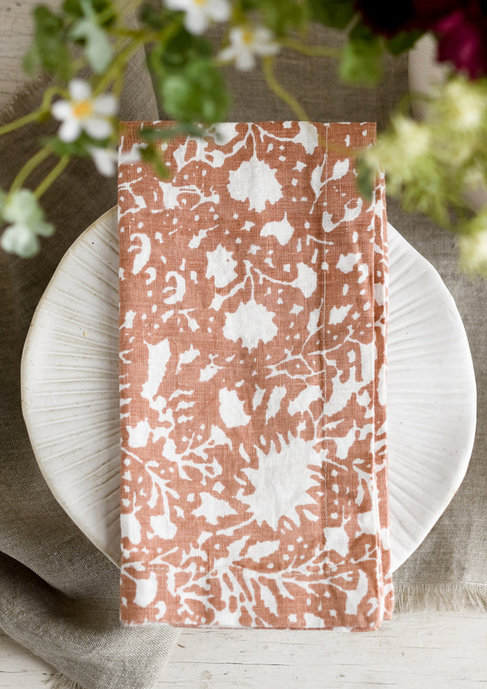 Clay Brown: A botanical print linen napkin in clay brown with white pattern.