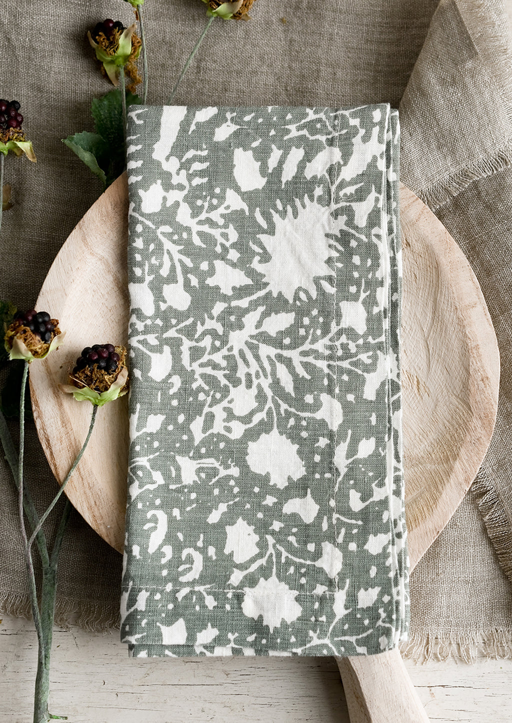 Sage Green: A botanical print linen napkin in sage green with white pattern.