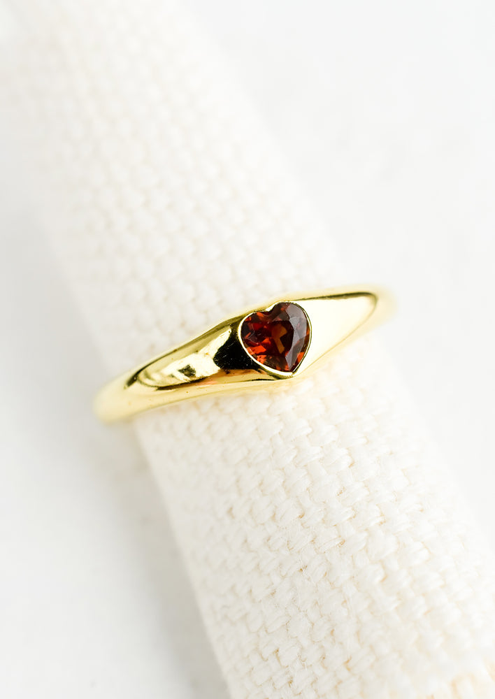1: An adjustable gold ring with heart shaped garnet stone.