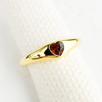 1: An adjustable gold ring with heart shaped garnet stone.