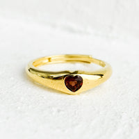 2: An adjustable gold ring with heart shaped garnet stone.
