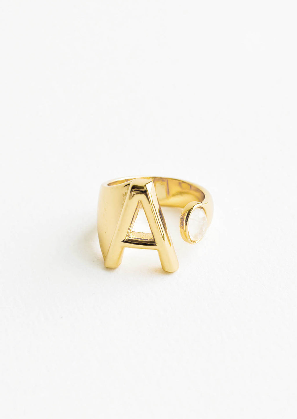 A: Yellow gold ring with letter A and oval glass crystal, and wide adjustable band.