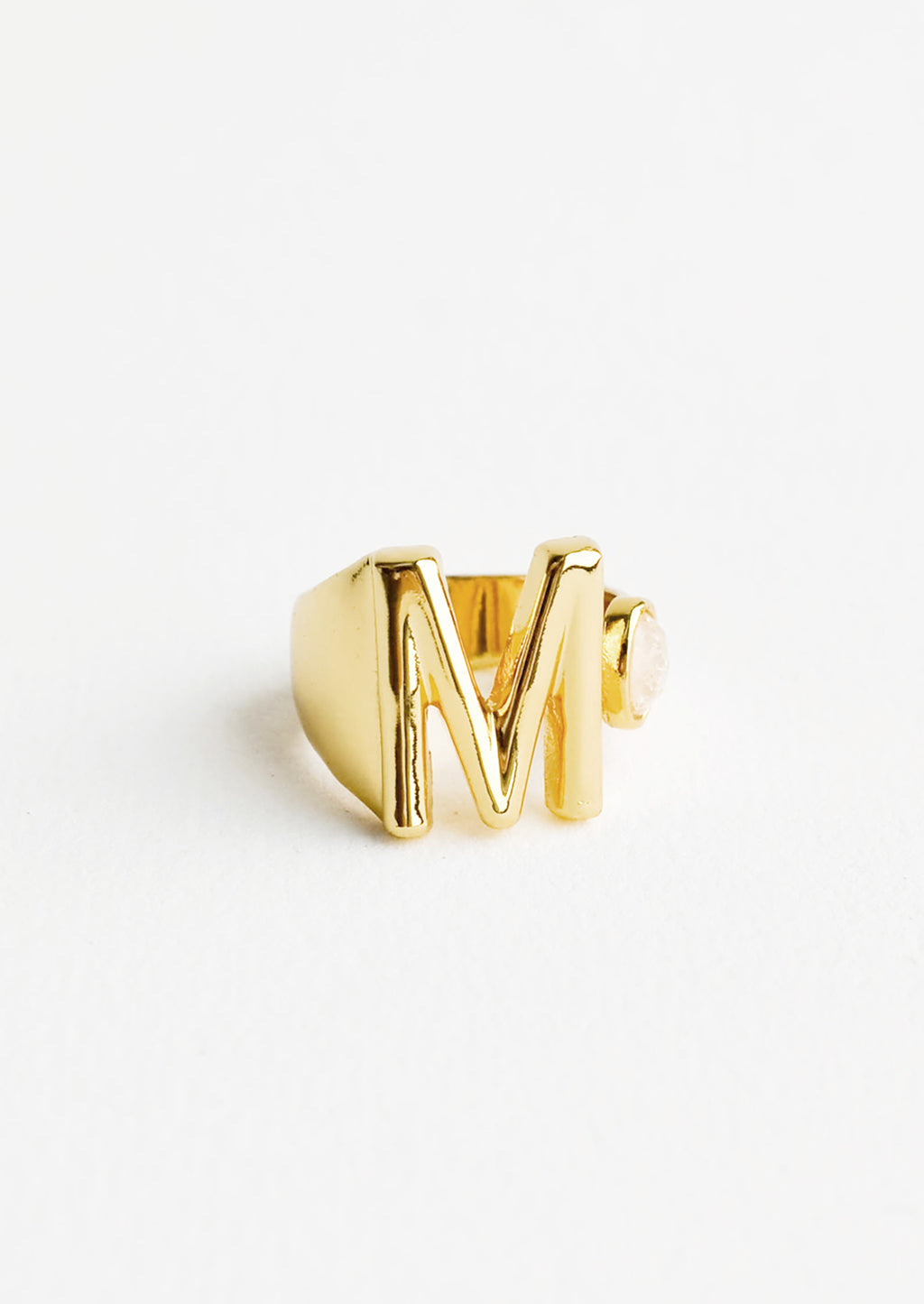 M: Yellow gold ring with letter M and oval glass crystal, and wide adjustable band.