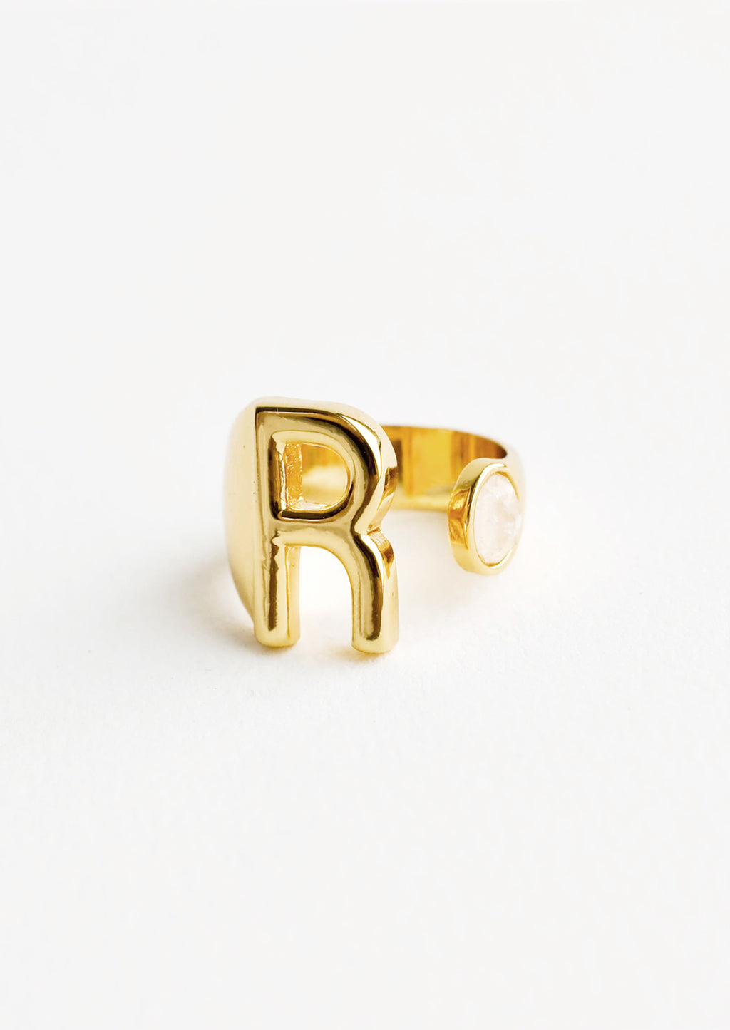 R: Yellow gold ring with letter R and oval glass crystal, and wide adjustable band.