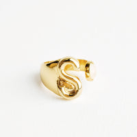 S: Yellow gold ring with letter S and oval glass crystal, and wide adjustable band.