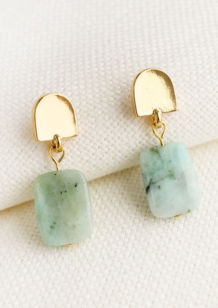 A pair of earrings with arch shaped gold post and chrysoprase stone.