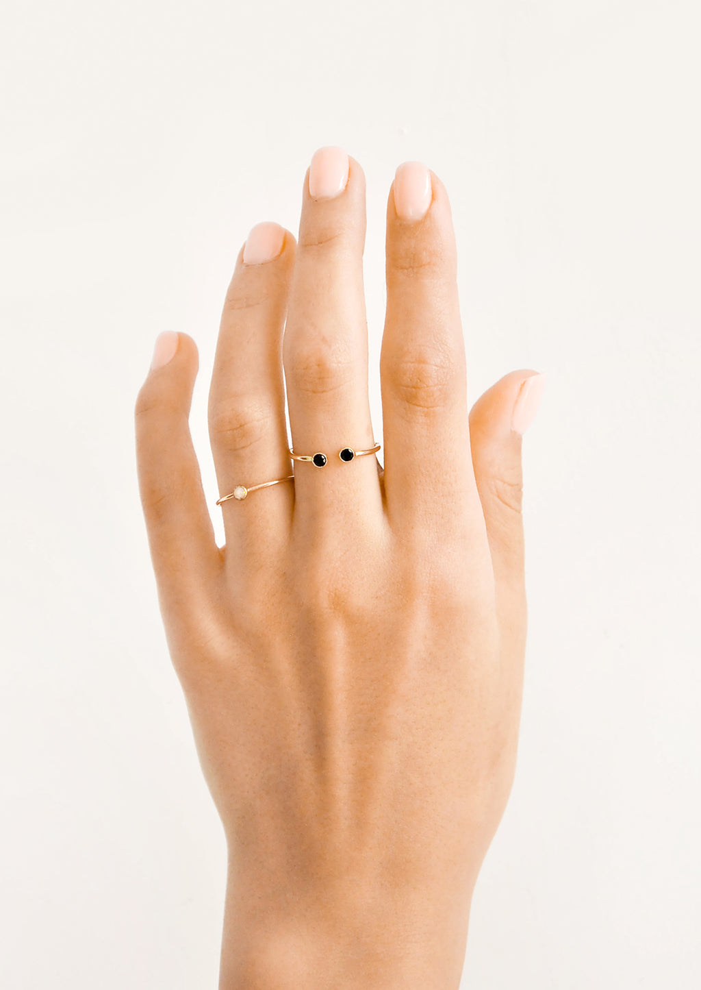 4: Model shot of hand wearing two gold rings with stones.