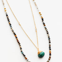 African Turquoise: A two-layer gold necklace with one strand of small, round multi-color stones and another of the thin gold chain and green gemstone pendant.