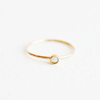 Opal / Size 5: Yellow gold ring with slim band and small white opal stone.