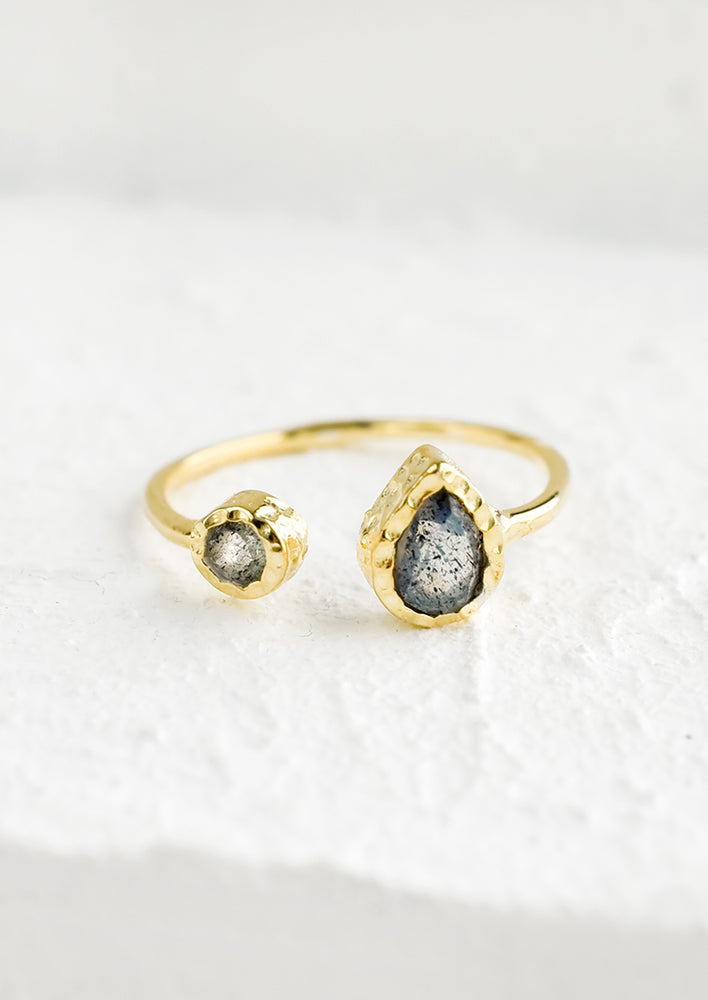 An open-ended gold ring with teardrop and round labradorite stones at either end.