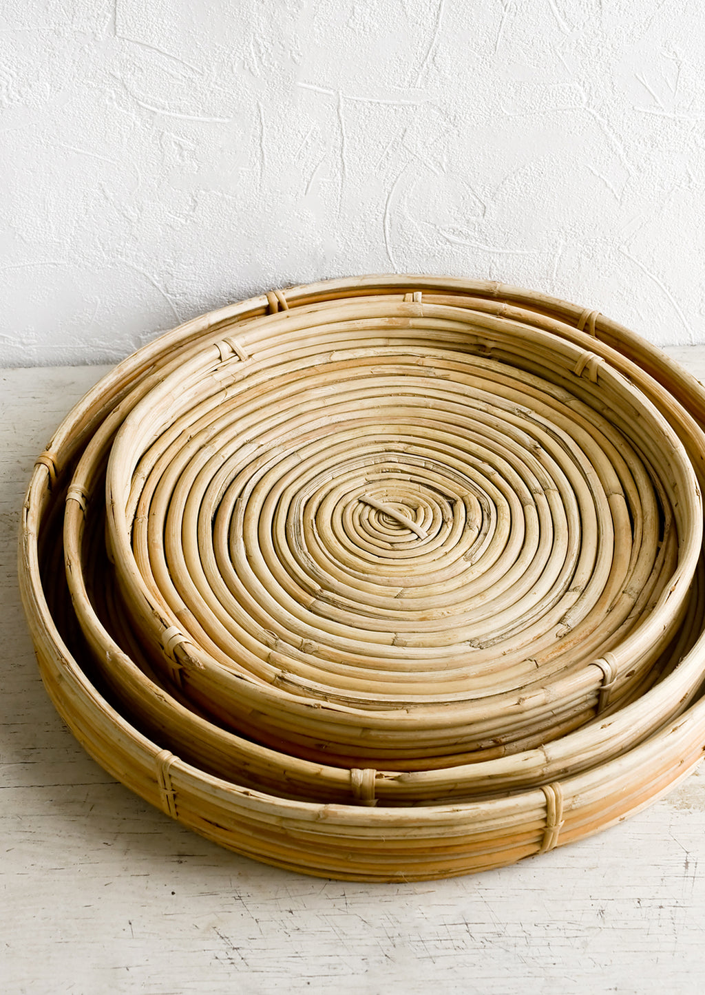 4: Shallow woven rattan trays in three incremental sizes.