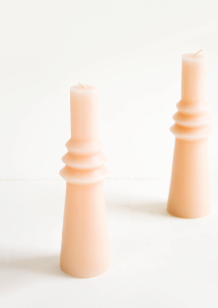 Shapely, peach colored pillar candle in skinny geometric form